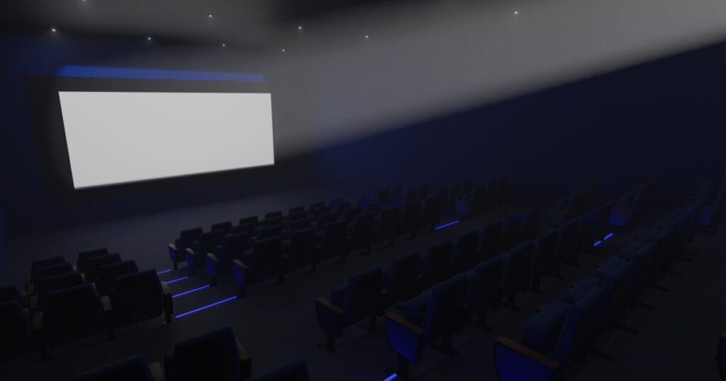 映画館のスクリーンに照らされるシアタールーム