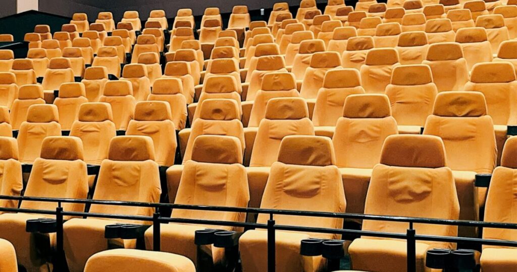 映画館の黄色い座席が並ぶ広い客席