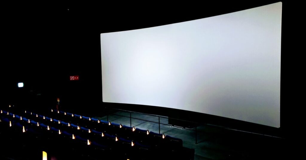 大きなスクリーンと暗闇の映画館内