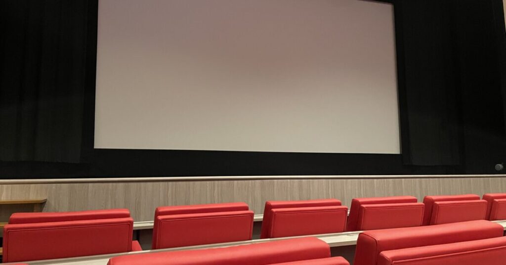 赤いソファ席とスクリーンのある映画館